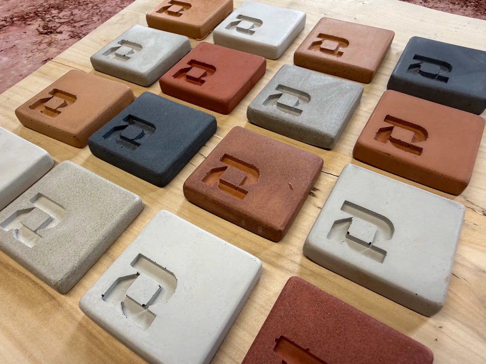 Concrete samples in a range of greys, laid out on an oak board