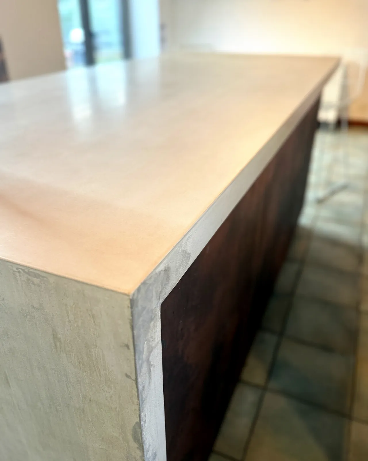 Close view of the island’s corner, where the pale concrete top turns down into the waterfall end